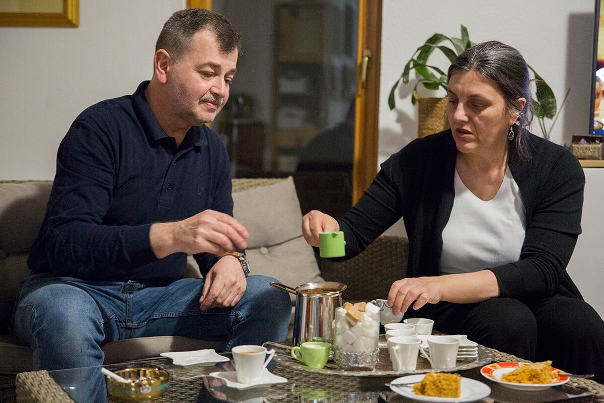 Manželia Omer a Nidžara servírujú kávu a koláč pre hostí po večeri. Foto: Zuzana Gogová