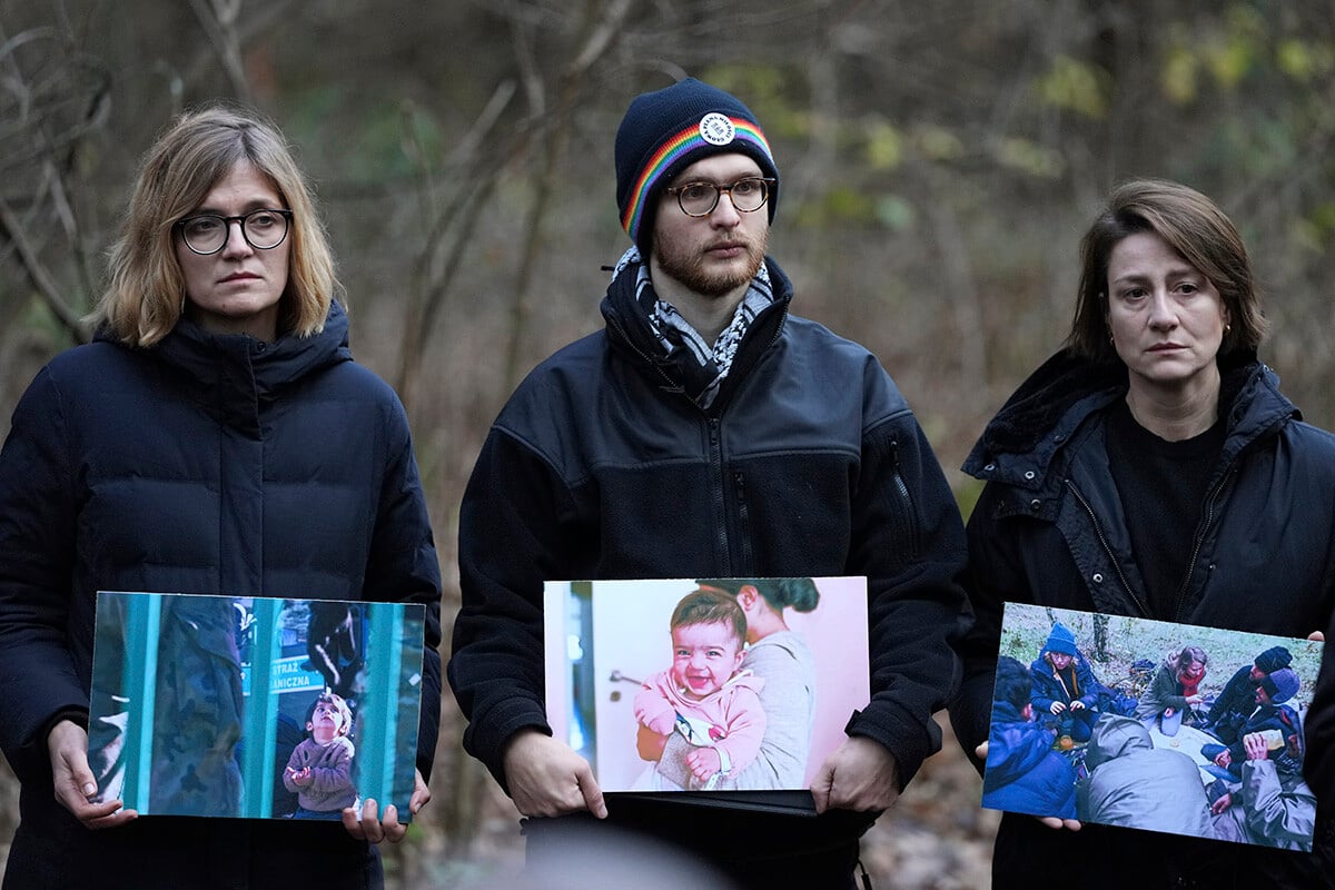 Členovia poľskej aktivistickej siete Grupa Granica s fotografiami migrantov. FOTO: SITA/AP