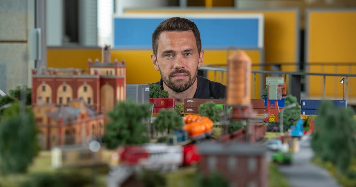 Na snímke muž skrývajúci sa za vlakovú diorámu