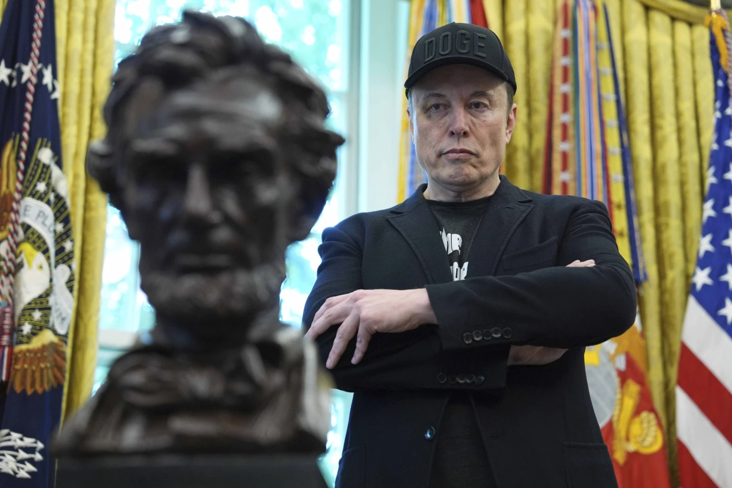 na snímke muž v šiltovke s prekrýženými rukami.