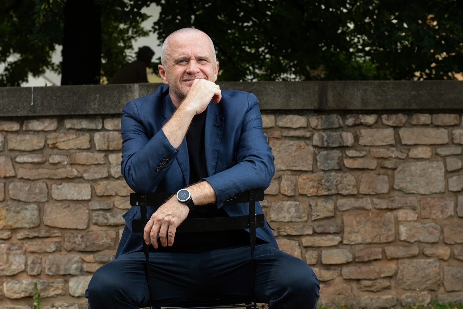 Na snímke sediaci muž v saku