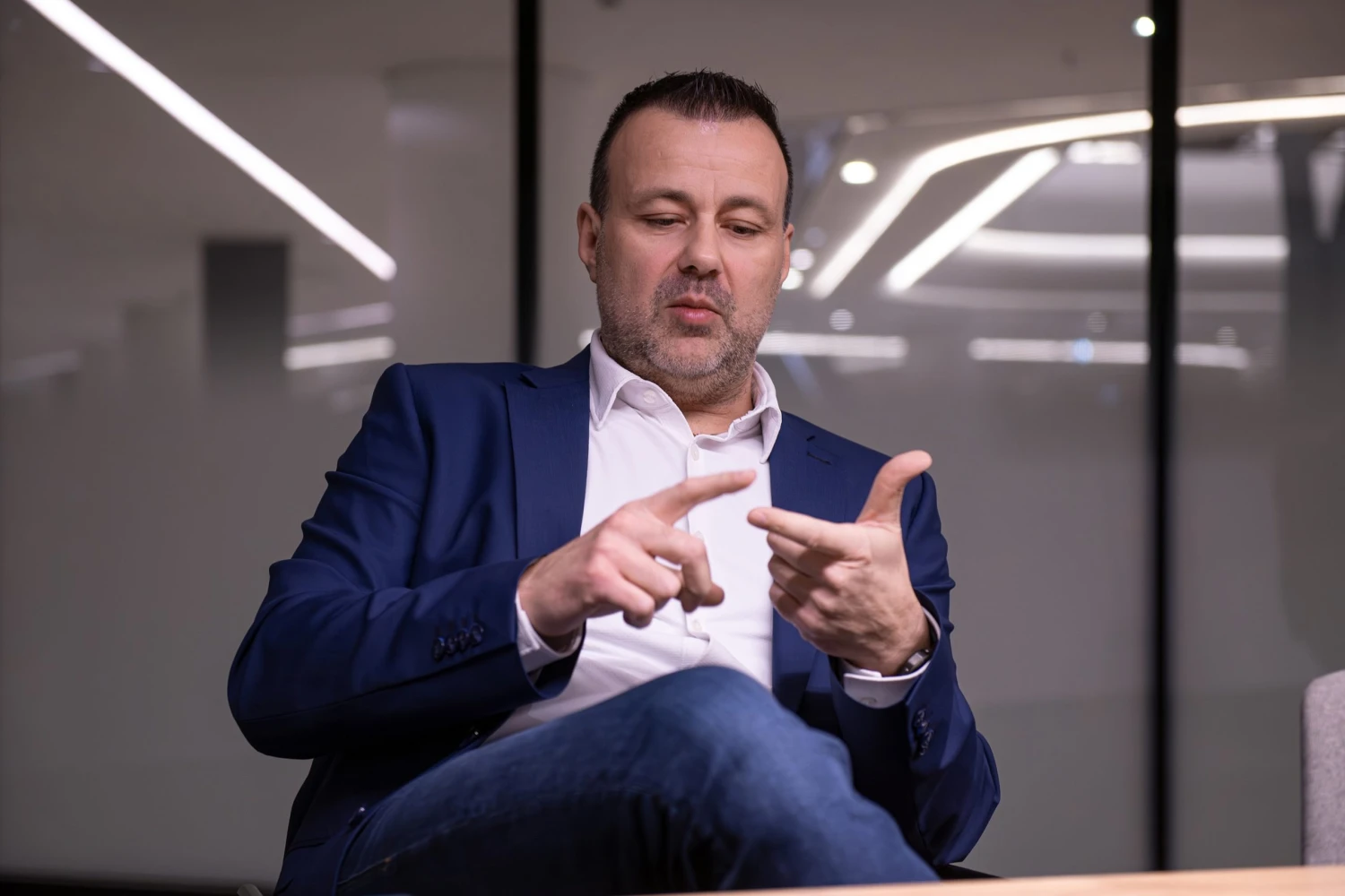 na snímke gestikulujúci muž v obleku